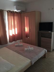 a bedroom with a bed with two towels on it at Apartmani Labovic in Budva
