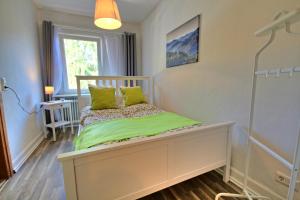 ein kleines Schlafzimmer mit einem Bett mit grünen Kissen in der Unterkunft Ferienwohnung Eulenhof in Neustadt an der Weinstraße