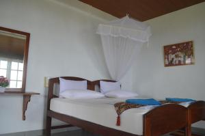 a bedroom with a bed with white sheets and a window at Hotel Paradiso in Hikkaduwa