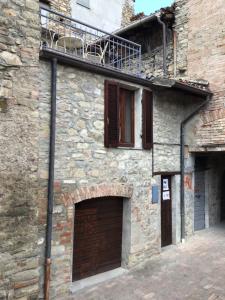 a stone building with two garage doors and a balcony at Varzi sotto i portici in Varzi