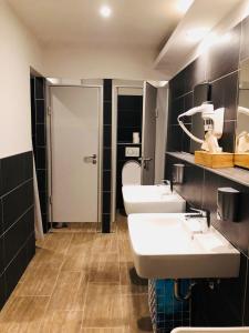 a bathroom with two sinks and a toilet at MAC City Hostel in Hamburg +44 photos