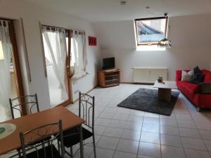 een woonkamer met een rode bank en een tafel bij Fa Haack in Neuried