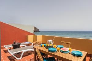 a table with food on top of a balcony with the ocean at Ocean View Penthouse II in Gran Tarajal