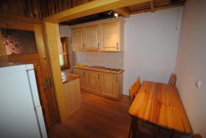 a kitchen with a wooden table and a refrigerator at Pokoje u Staszka in Bukowina Tatrzańska
