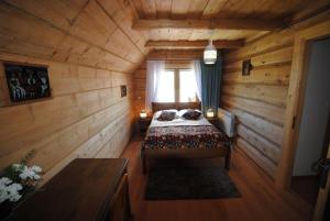 a bedroom with a bed in a wooden cabin at Pokoje u Staszka in Bukowina Tatrzańska