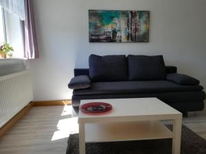 ein Wohnzimmer mit einem Sofa und einem Tisch in der Unterkunft Haus Linde Frauenwald am Rennsteig in Frauenwald