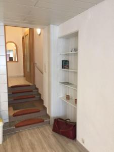ein Zimmer mit einer Treppe und einem Flur mit einem Spiegel in der Unterkunft Haus Linde Frauenwald am Rennsteig in Frauenwald