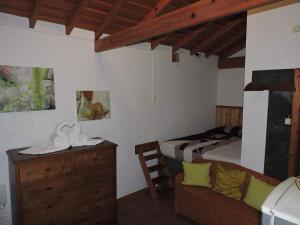 een slaapkamer met een bed en een dressoir in een kamer bij Casas de Campo HousesInPico in Prainha de Baixo