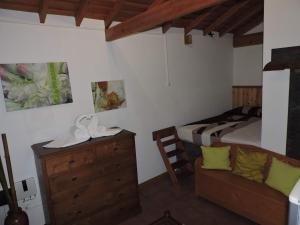 1 dormitorio con 1 cama, vestidor y silla en Casas de Campo HousesInPico, en Prainha de Baixo