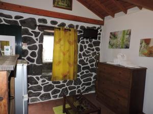 a kitchen with a stone wall at Casas de Campo HousesInPico in Prainha de Baixo