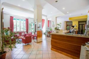 einen Salon mit rosa Stühlen und einer Theke in der Unterkunft Hotel Mediterraneo in Cefalú