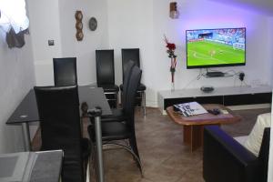 a living room with a tv and a table and chairs at Apartments Nora & Lucija in Baška