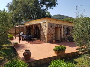 a stone house with a patio and a table at Agriturismo Valborgina in Castiglione della Pescaia