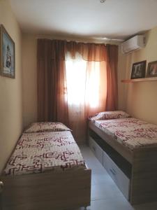 two beds in a small room with a window at APplaya in El Puerto de Santa María