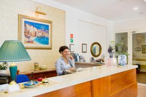 a woman sitting at a counter in a salon at Hotel Mediterraneo in Cefalù