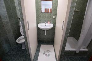 a small bathroom with a sink and a toilet at Népliget Hotel in Budapest