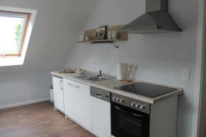 une cuisine avec un évier et une cuisinière dans l'établissement FEWO Familie Werner, à Erfurt