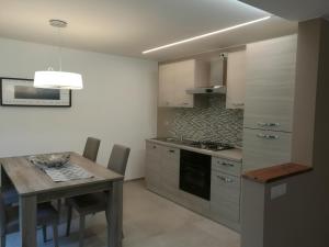 a kitchen with a wooden table and a dining room at B&B La Maison D' Amelie Camere e Appartamenti in Fenis