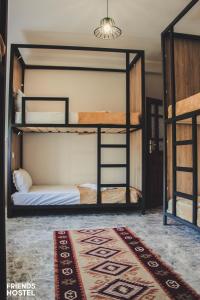 2 Etagenbetten in einem Zimmer mit einem Teppich in der Unterkunft Friends' Guesthouse & Hostel in Gjirokastër