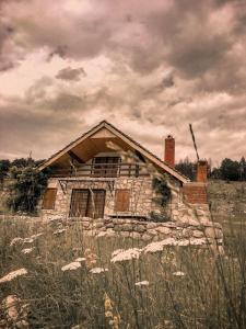 an old stone house sitting in a field at Mountain house Varda in Ledenice