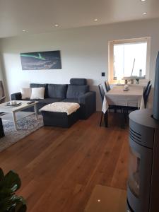 una sala de estar con un sofá y una mesa en Apartment near the airport with ocean view, en Tromsø