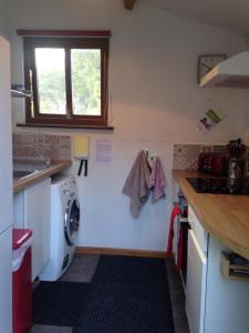 a small kitchen with a washing machine and a window at The Shippon at RoseHip in Launceston