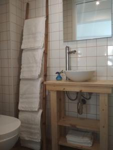 ein Badezimmer mit einem Waschbecken und einem Stapel Handtücher in der Unterkunft Cassiopeia Duplex in Setúbal