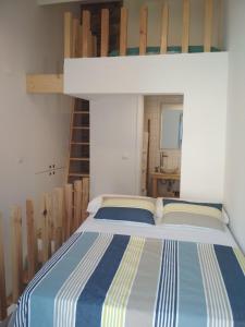 ein Schlafzimmer mit einem Etagenbett mit einer Leiter in der Unterkunft Cassiopeia Duplex in Setúbal