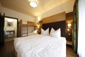 a bedroom with a large white bed and a mirror at Haus Mozart in Schladming