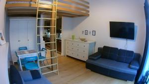 a living room with a blue couch and a tv at DUNE Apartments in Mielno