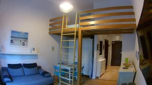 a living room with a blue couch and a loft bed at DUNE Apartments in Mielno +33 photos