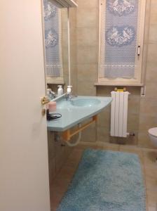 a bathroom with a sink and a blue rug at Appartamento al mare Puglia in Ginosa Marina +10 photos