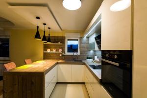 a kitchen with white cabinets and a wooden counter top at Apartments Sandra in Rijeka