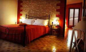 1 dormitorio con cama y pared de ladrillo en B&B Villa Mirella, en Casnate con Bernate