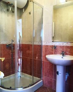 een badkamer met een glazen douche en een wastafel bij Sutomore apartments Anika in Sutomore
