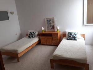 Un dormitorio con dos camas individuales y una cómoda. en Superbe Appartement bord de mer, en Sousse
