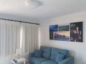 a living room with a blue couch and a window at Apartamento704 Mesa del Mar in Tacoronte