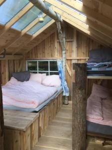 Zimmer mit 2 Betten in einem Blockhaus in der Unterkunft Treehouse B&B in Rabjerg
