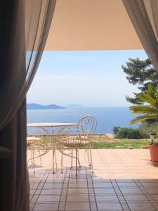 uma mesa e cadeiras num pátio com vista para o oceano em Stella d'Argento em Porto Santo Stefano