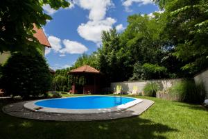 una piscina en un patio con cenador en Szépkilátás Vendégház, en Balatonfűzfő