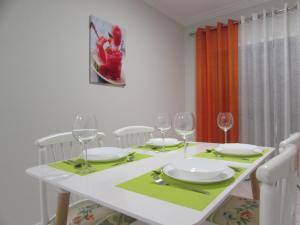 einen weißen Esstisch mit Weingläsern und einem Tischtuch in der Unterkunft Ar Puro III in Viana do Castelo