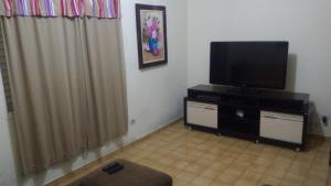 a living room with a flat screen tv on a dresser at Nossa Casa in Cunha