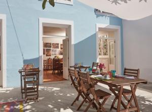 a dining room with a wooden table and chairs at Casadacidade in Ponta Delgada