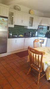 a kitchen with a table and chairs and a refrigerator at Tulla Villa Self Catering in Riverstown