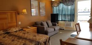 a hotel room with a bed and a couch and a chair at Tara Vista Inn in Hinton