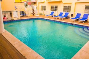 a large swimming pool with blue chairs in a hotel at Fantastic Hotel in Marigot