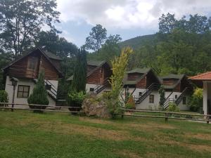 a row of houses in a yard with a fence at Lisine smeštaj Vodopad in Strmosten +83 photos