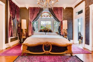 a bedroom with a large bed with a chandelier at The Holiday Chalet Victorian in Denver