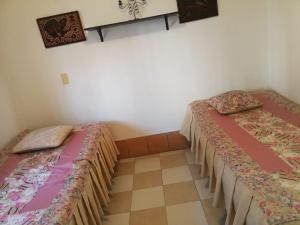 two beds sitting next to each other in a room at Hospedaje Nuestra Casa in Guatapé