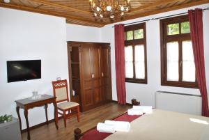 a bedroom with a bed and a table and a chair at Hotel Kastro in Gjirokastër